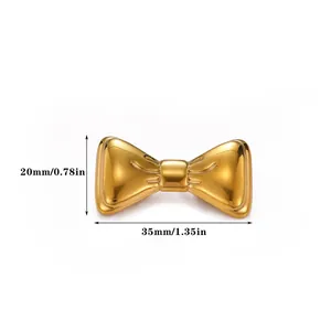 Détail d'une broche nœud dorée en métal vintage montrant les dimensions 35mm x 20mm