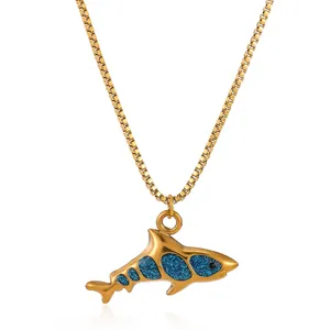 Close-up of golden shark pendant with blue glitter inlay and durable box chain