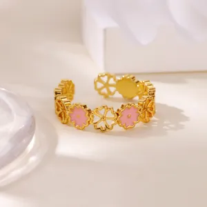 Detail of pink zircon heart flower patterns on golden stainless steel open ring