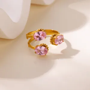 Close-up of pink oval gemstones on a gold adjustable stainless steel heart flower ring
