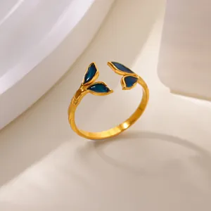 Detail view of adjustable gold-plated ring with leaf-shaped dark blue enamel inserts