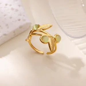 Detail of vintage golden leaf ring with pale green cat eye stones and adjustable band