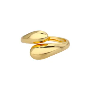 Detalle del anillo de doble gota asimétrica dorada con acabado de espejo pulido
