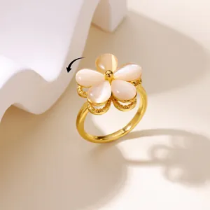Detailed view of rotatable flower ring with pink cat eye stones and gold finish