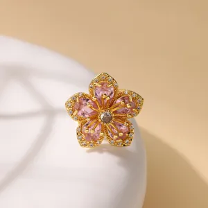 Luxury gold ring with pink zircon flower petals and crystal pavé on white stand
