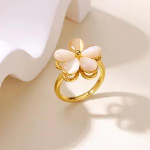 Elegant gold flower ring with opal-style petals and zircon details on a neutral base