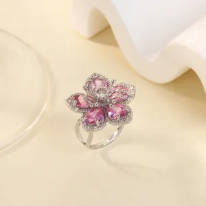 Close-up of sparkling pink zircon flower ring with silver petals and micro-diamond accents