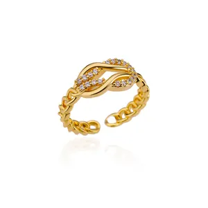 Detail of gold floral knot ring with zircon stones and cuban link textured band