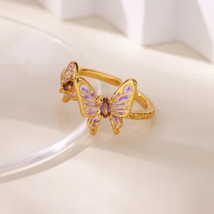 Detail of a gold-plated butterfly ring featuring purple enamel and a central zircon gemstone