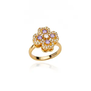 Macro detail of 18K gold ring with purple clover floral pattern and tiny white zircon stones