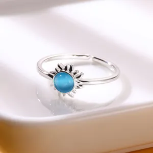 Macro shot of sun-shaped ring with blue moonstone center and radiating silver rays