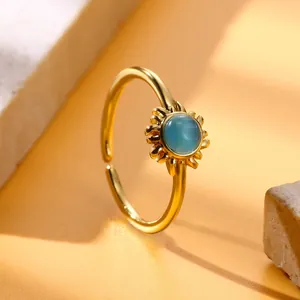 Macro shot of gold sunburst ring featuring a blue cat-eye stone with adjustable band