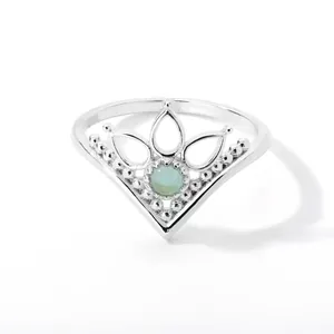 Macro shot of a silver V-shaped crown ring with green stone and milgrain details