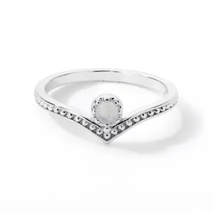 Detailed close-up of a silver V-shaped ring featuring a round moonstone and milgrain edges