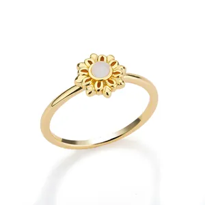 Detail of gold daisy ring featuring 12 carved petals and a polished moonstone center