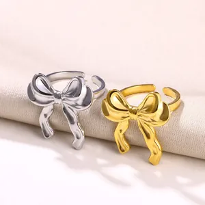 Detailaufnahme von Schleifenringen in poliertem Gold- und Silber-Finish auf Stoff