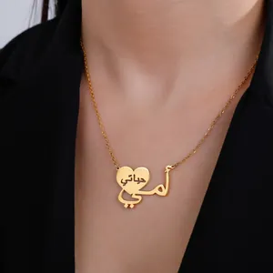 Collana a cuore dorata con ciondolo arabo su modella in giacca da abito nera