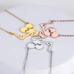 Three heart pendants with Arabic script in gold, rose gold, and silver on a white tray