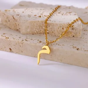 Detailopname van de 18K vergulde Arabische letter hanger aan een verfijnde ketting