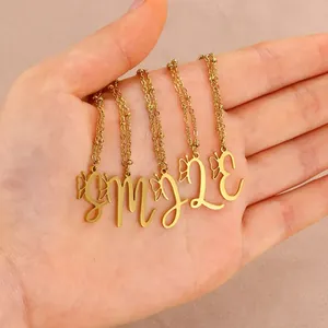 Close-up of gold stainless steel butterfly necklaces with cursive letter pendants