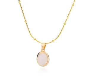 Close-up of gold titanium necklace with oval pink opal pendant and beaded chain detail