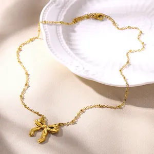 Elegante goldene Halskette mit Schleifenanhänger und Perlenkette auf Seidenhintergrund