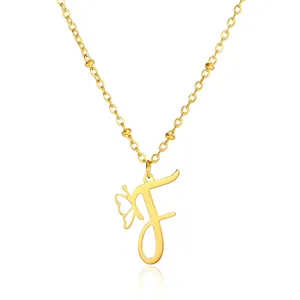 Detail of gold butterfly necklace with letter F pendant on satellite bead chain