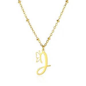 Close-up of golden necklace featuring a cursive J letter pendant and a hollow butterfly
