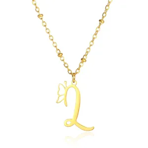 Macro shot of gold letter L pendant with butterfly wing detail on beaded cross chain
