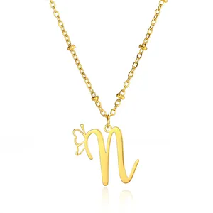 Detail of golden letter N pendant with hollow butterfly wing and beaded cable chain