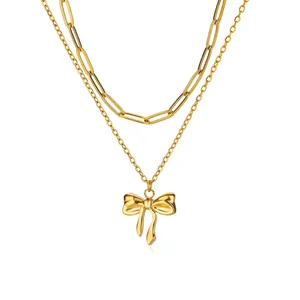 Detail der doppelten Goldkette mit Büroklammer-Design und poliertem Schleifen-Anhänger