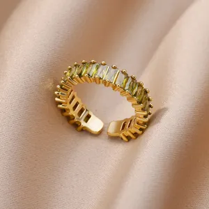 Makroaufnahme eines 18K vergoldeten Rings mit grünen Zirkonia auf Champagner-Seide