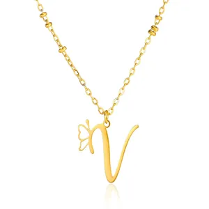 Macro shot of gold V pendant necklace with cutout butterfly and beaded chain detail