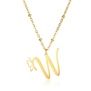 Macro view of gold butterfly and cursive letter W pendant on beaded chain
