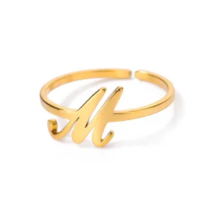 Detailopname van een gepolijste gouden verstelbare ring met een stijlvol letter M design