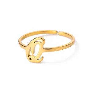 Macro-detail van verstelbare gouden ring met cursieve letter Q en gepolijste afwerking