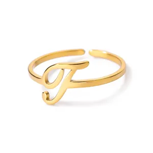 Macro detail van verstelbare gouden ring met cursieve letter F en hoogglans