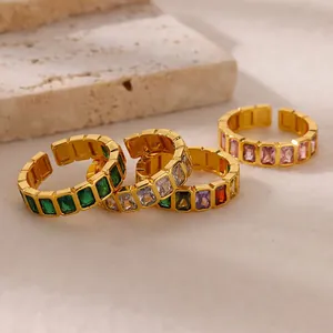 Close-up of four 18K gold plated adjustable rings with emerald and pink zircon stones