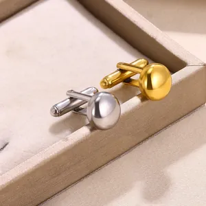 Polished silver and gold round dome cufflinks for men shirts on beige jewelry tray
