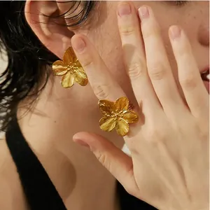 Golden flower earring and ring set with brushed metal texture worn by model