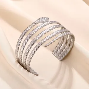 Gros plan d'un bracelet spirale argenté multicouche avec texture peau de serpent