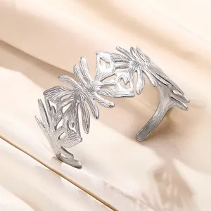 Détail d'un bracelet ouvert en acier inoxydable argenté avec motif de feuilles ajourées