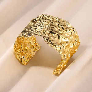 Detail showing the hammered texture and golden metallic finish of the wide cuff bracelet