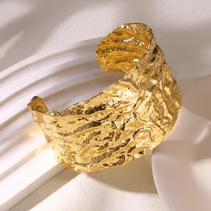 Detailed view of the crinkled texture on an 18K gold plated wide cuff bracelet