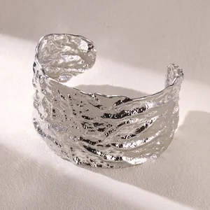 Macro shot of silver textured irregular wide open cuff bracelet with molten lava metallic finish