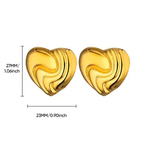 Vista detallada de pendientes de corazón dorados con textura de onda y medidas 27mm