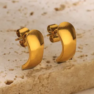 Detailed close-up of high-polished gold water drop stud earrings on stone background