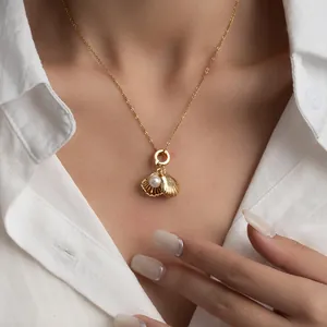 French style gold shell pendant necklace with pearl on elegant woman in white shirt