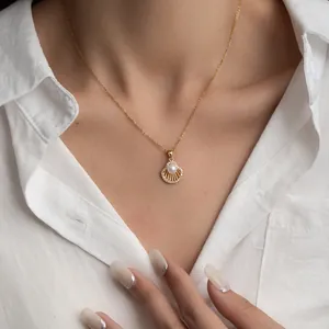 Elegant gold titanium necklace with hollow scallop shell pearl pendant worn by model