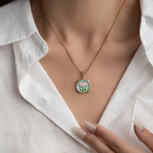 Dettaglio della collana con ciondolo smaltato quadrato e perla naturale indossata